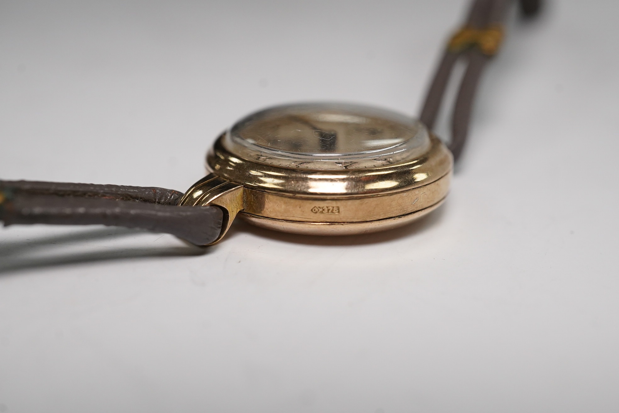 A lady's 9ct gold Rolex manual wind wrist watch, with Arabic dial and subsidiary seconds, case back numbered 22110, case diameter 21mm, on an associated twin strand fabric strap. Condition - poor to fair